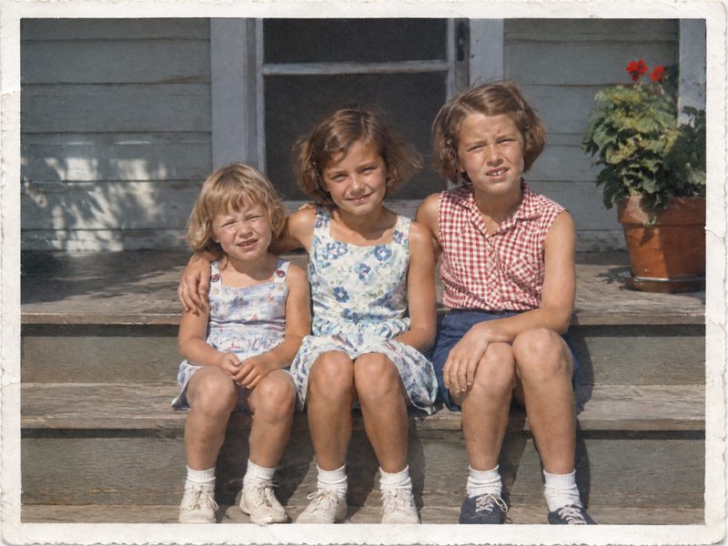 After: the corner and scratches repaired, same three girls